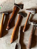 Group shot of six vintage tools on concrete floor