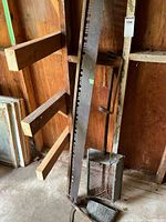 Full view of scythe, dustpan and sieve leaning against wall