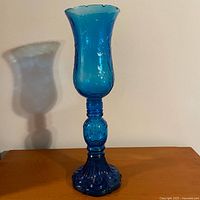 Photo showing the assembled blue Empoli-style glass hurricane lamp with embossed floral pattern from the front side.
