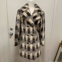 Full front view of the brown and white faux fur coat on a mannequin, showing length and pattern.
