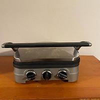 Front view of the Cuisinart Griddler showing three control knobs and sturdy floating handle.