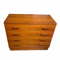 Front view of the wooden four drawer dresser showing the rectangular shape, wood grain finish, and two wooden pulls on each drawer.