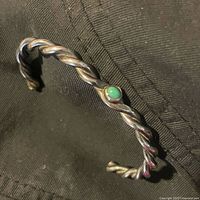 Front side of the twisted sterling silver Navajo bracelet showing turquoise stone at center