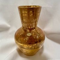 Front angled photo of Stangl pottery vase showing original sticker and gold textured finish with leaf pattern at bottom