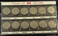 Front view of two rows of 25 cent coins in plastic display strip showing all 12 Canadian provinces and territories from the 1867-1992 Confederation 125 Year Commemorative coin set.