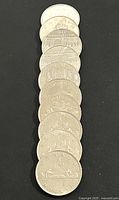 Stack of 10 Canadian silver dollar coins showing reverse designs commemorating Canadian heritage events and themes.