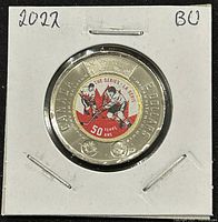 Front view of the coin in holder showing the 50th anniversary hockey players colorized design.