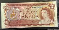 Front side of 1974 Canadian $2 banknote showing Queen Elizabeth II portrait, serial number and denomination details.