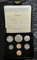 Set of 7 Canadian coins in black display case with a specification card above showing coin details, metal content, weights, and diameters.