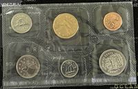 Front view of the six coins in sealed plastic holder showing various designs and colors, from different countries.