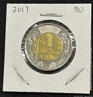 Front side of the 2017 Canadian Battle of Vimy Ridge twoonie coin showing the brass-plated aluminum bronze center with Vimy Ridge memorial and soldier figures.