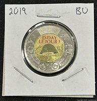 Front side of the 2019 Canadian D-Day Invasion two-dollar coin showing the soldier's helmet and commemorative text.