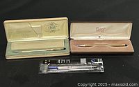 All items in the lot showing two pens in their respective original boxes and an unopened refill pack.