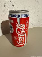 Front and side view of a 355ml Coca-Cola Classic aluminum can with 1992 World Series Blue Jays Champions commemorative design in red, white and blue colors.