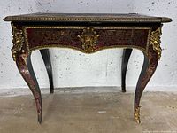 Full frontal view of desk showing curved legs and single drawer.