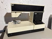 Full side view of PFAFF Tipmatic 1027 sewing machine on table, showing body, needle, presser foot and control area.