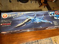 Box showing the SU-34 Fullback model jet with branding, model name, and specifications including 35.5 inch wingspan and 57 inch length.