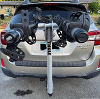 Front view of the Thule bicycle rack mounted on a vehicle hitch, showing two arms with adjustable black rubber securing straps.