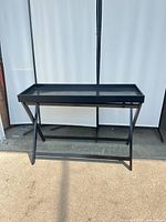 Front view of black folding tray sideboard table