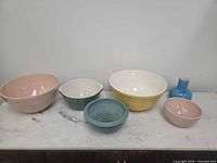 Group shot showing five bowls and one vase in assorted colours
