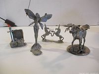 Front view of all four pewter figurines aligned