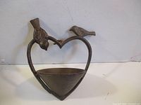 Front view of heart-shaped cast iron bird feeder with birds