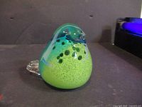 Front view of green and teal glass bird paperweight