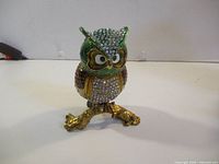 Front view of rhinestone-encrusted enamel owl trinket box on branch base