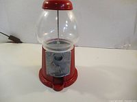 Front view of red gumball machine showing coin mechanism and globe