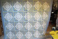 Full view of entire quilt hanging, showing patchwork design