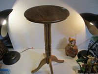 Full view of round plant stand between lamps
