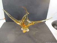 Full view of sculptural amber glass centerpiece with elongated arms and clear base