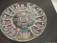 Full view of iridescent glass deviled egg plate showing twelve egg wells and center pattern