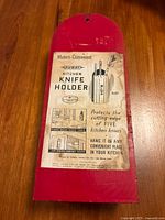 Front of the wooden kitchen knife holder showing red painted back with original printed paper label describing product as a Modern Convenient Nuway Kitchen Knife Holder from 1939.