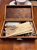 Overall view of the Mirro cooky-pastry press assembly in a wood box with the original instruction booklet on top, indicating a vintage baking utensil set.