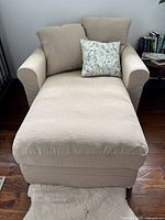 Front view of beige chaise lounge with rolled arms, seat cushion and back cushions