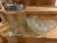 Large glass drink dispenser and glass punch bowl with 8 glasses inside punch bowl, showing the set contents and condition.