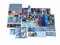 Overview of multiple plastic trays filled with assorted beads sorted by color and type, plus several zip-lock bags with additional beads