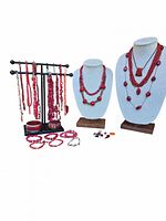 Wide shot of the coral jewelry lot including multiple necklaces on busts and hanging on stand, assorted bracelets and loose beads spread in front