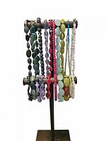 Photo showing ten gemstone necklaces with matching bracelets in various colors displayed on a metal stand. The pieces include green, purple, red, yellow, blue, and clear colored beads.
