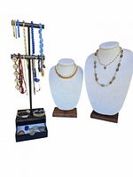 Photo of the jewelry lot showing multiple necklaces and bracelets on stands and display boxes.