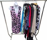 Full rack of assorted resale designer clothing including dress, sweaters, tops in various colors and patterns