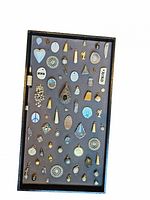 Full top-view image of the tray with 53 small pendants and charms arranged in rows, showing variety in shape, size, and material.