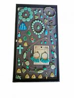 Tray of turquoise style jewelry items including necklaces, pendants, earrings, bracelets, and charms.