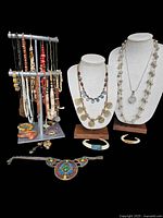 Lot of vintage ethnic/tribal necklaces, bracelets, and pendants arranged on jewelry stand and display busts