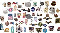Wide view of the full collection of pins, medallions, and a patch showing variety of designs, colors, and types.