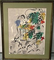Framed print signed Marc Chagall, showing bright floral and figurative design with green mat and gold-tone frame.