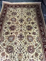 Full view of rug laid flat showing overall Tabriz-style floral vine pattern