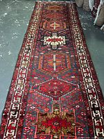 Full length view of the wool runner rug showing the central geometric medallions and border design.