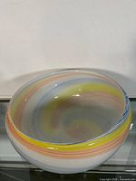 Front and side view of the large blown glass bowl showing multicolored swirl design.